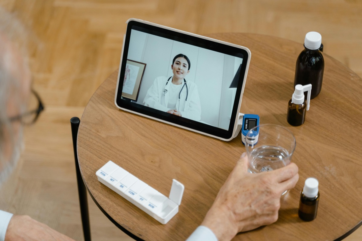 Patient on a video call with a doctor from a couch at home
